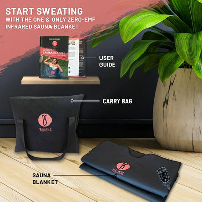 Zero-EMF infrared sauna blanket set with carry bag, user guide, and potted plant on a wooden surface.